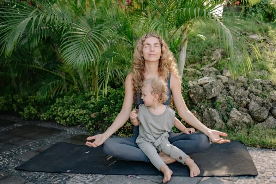 mother doing yoga with a child on her lap