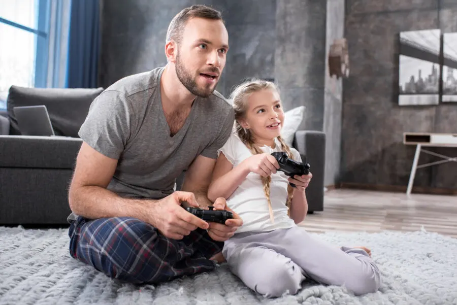dad playing video game with daughter