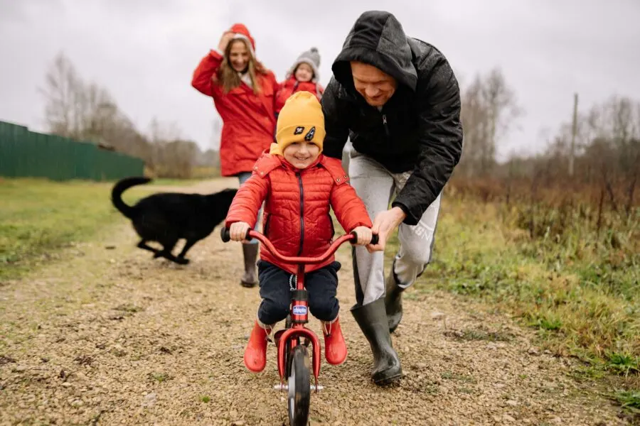 parent teaching child to ride bike