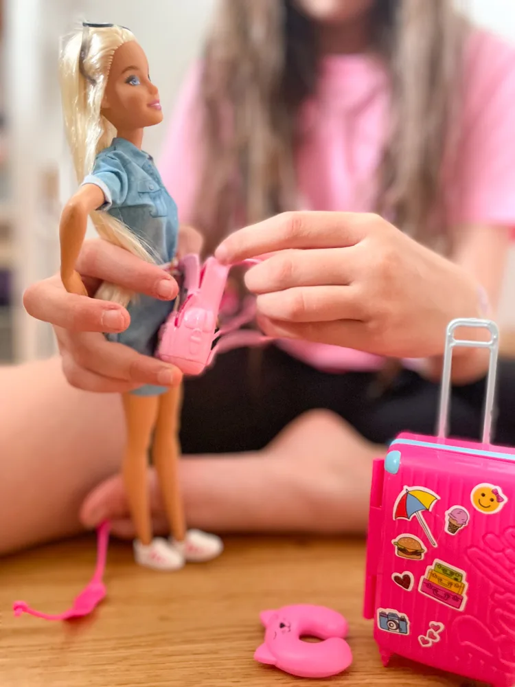 Girl playing with travel barbie