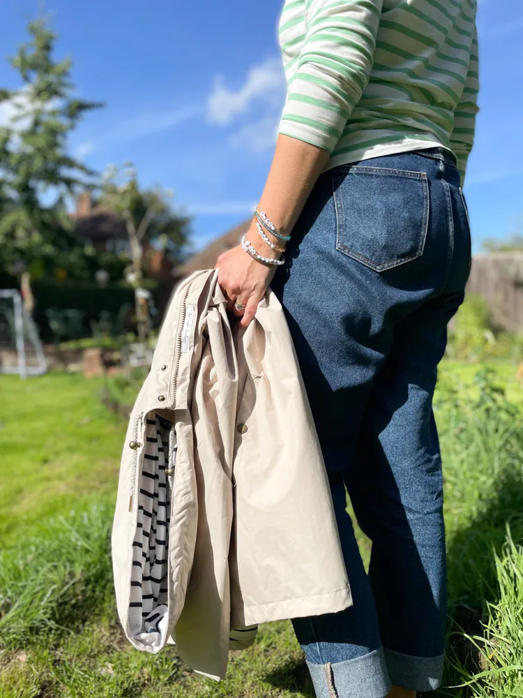woman walking in a garden holding her coat