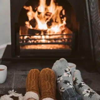 Cosy fire with people toasting their feet