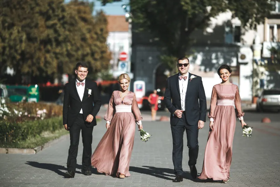 group-smiling-groomsmen-bridesmaids-walking