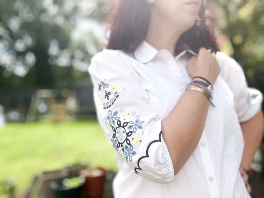 Woman wearing blouse with embroidered sleeve