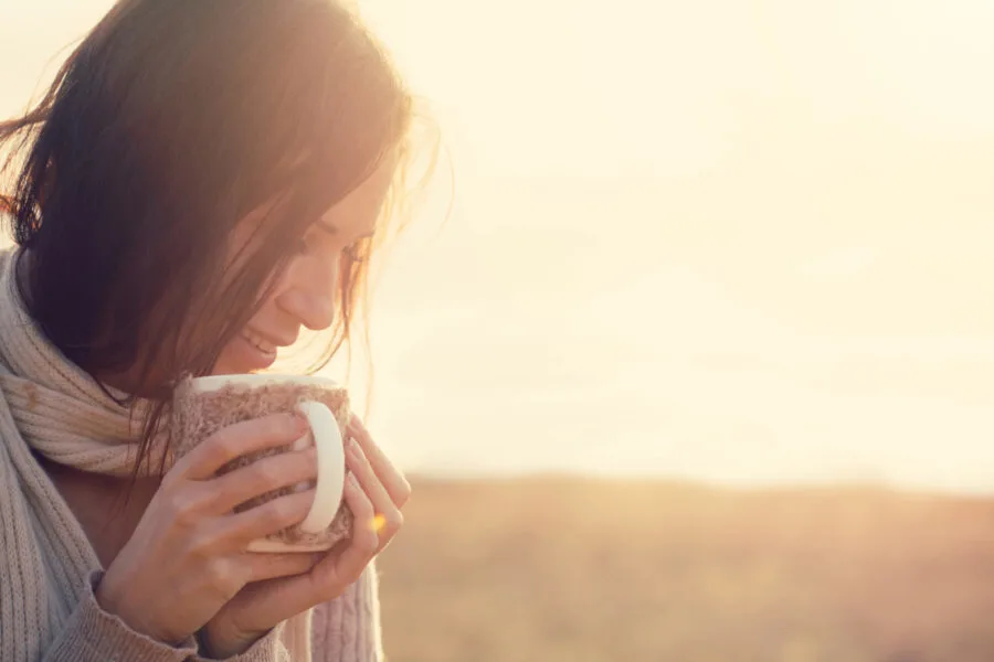 woman holding mug sunset